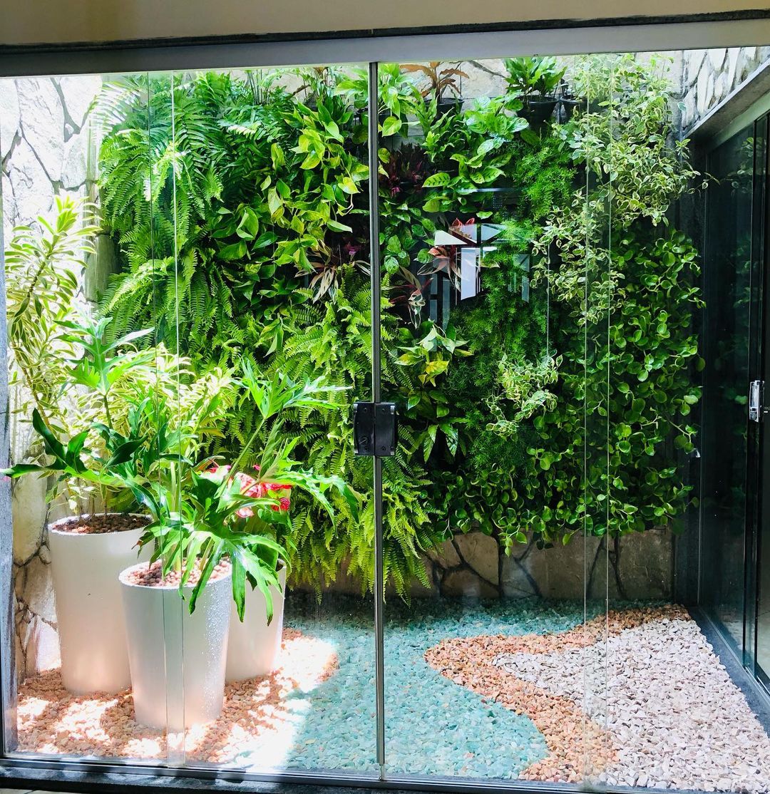 Jardim vertical com samambaias e vasos brancos